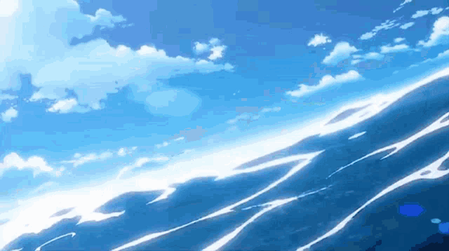 a blue ocean with white waves and a blue sky with white clouds