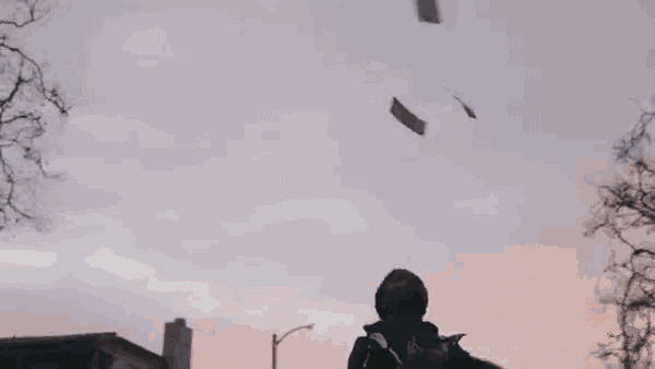 a man is throwing a frisbee in the air in front of a street light .