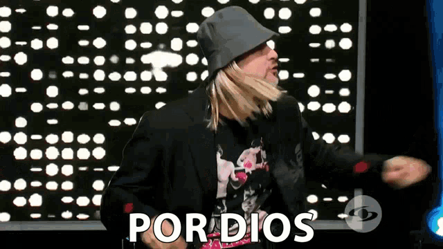 a man wearing a hat and a jacket says por dios on the screen