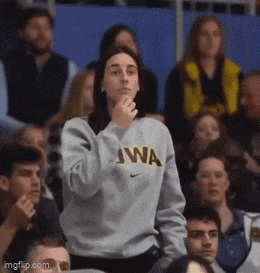 a woman wearing a sweater that says iowa on it stands in a crowd