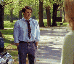 a man in a blue shirt and tie stands next to a woman in a green shirt