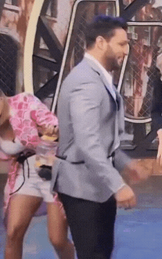 a man in a suit is dancing in front of a woman in a pink dress