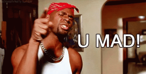 a man wearing a bandana and a white tank top is giving a thumbs up and says u mad !