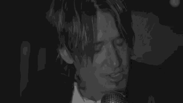 a man in a suit and tie singing into a microphone