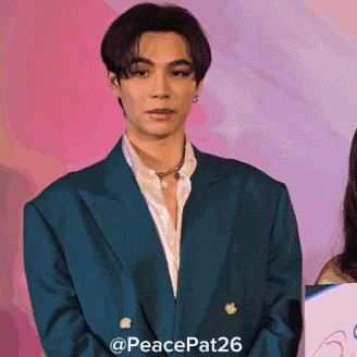 a man in a blue suit is standing in front of a pink and purple background with the hashtag peacepat26