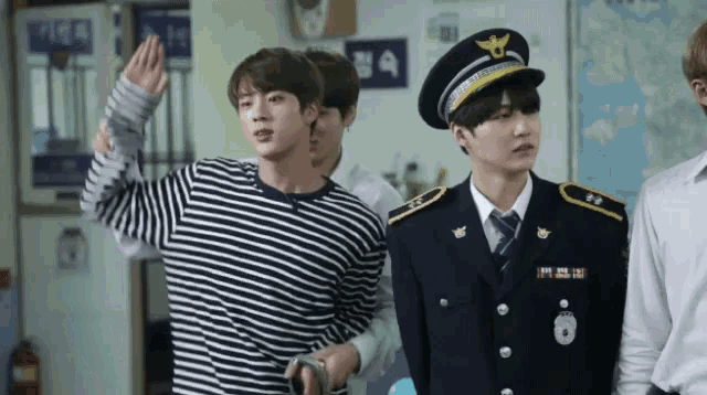 a man in a police uniform stands next to another man