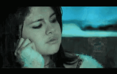 a woman is talking on a cell phone in a car while looking out the window .