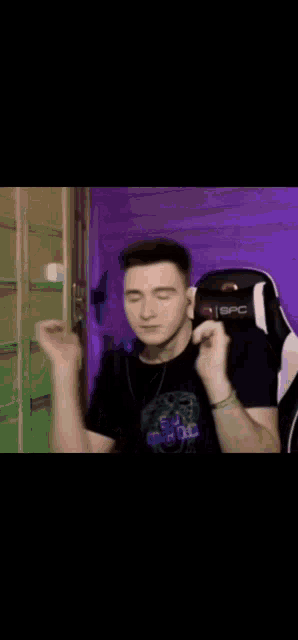 a man is sitting in a chair with his hands on his face .