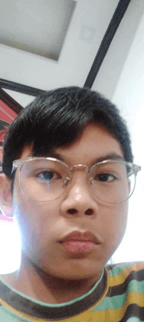 a young boy wearing glasses looks at the camera