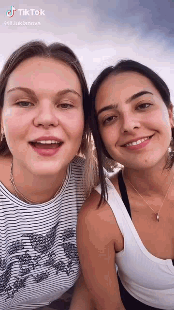 two women are standing next to each other and smiling for a picture .