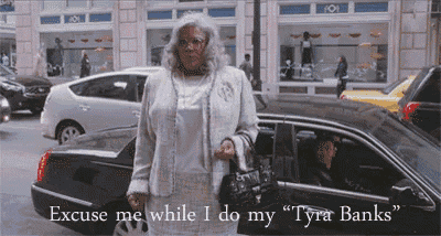 a woman standing in front of a car with the words " excuse me while i do my tyra banks " on the bottom