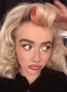 a woman with curlers in her hair making a face