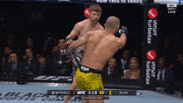 two men are fighting in a boxing ring and one of them is wearing a venum belt