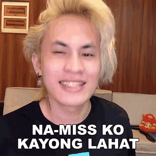 a man with blonde hair is smiling and has the words na-miss ko kayong lahat above his head