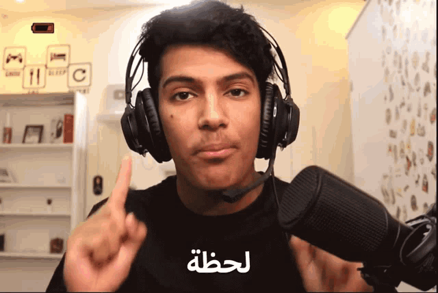 a man wearing headphones and a microphone with arabic writing
