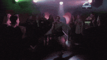 a blurry picture of a person 's face with green and purple lights behind them