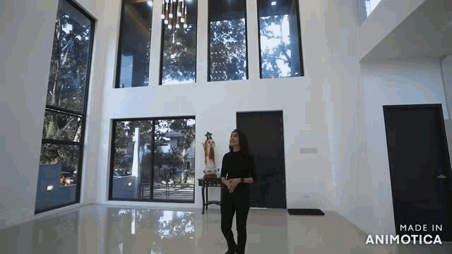 a woman is standing in a room with lots of windows and the words made in animotica above her