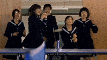 a group of young girls are playing ping pong