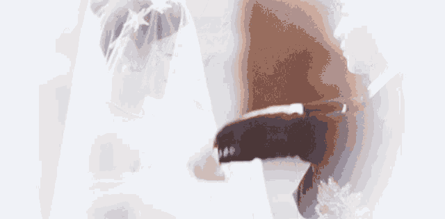 a bride and groom are holding hands on their wedding day in a church .