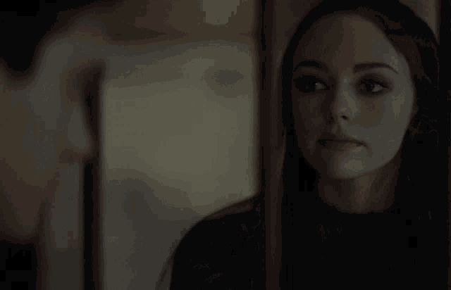 a woman is looking at herself in a mirror .