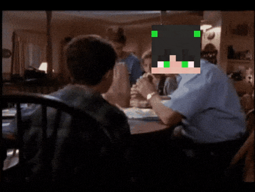 a man with green eyes sits at a table with a group of children