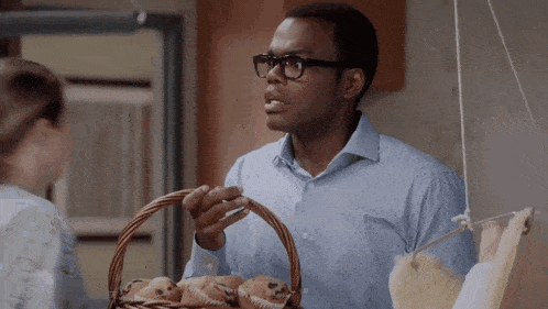 a man holding a basket of muffins looks surprised