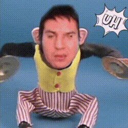 a stuffed monkey with a man 's face on it and the word uh behind it