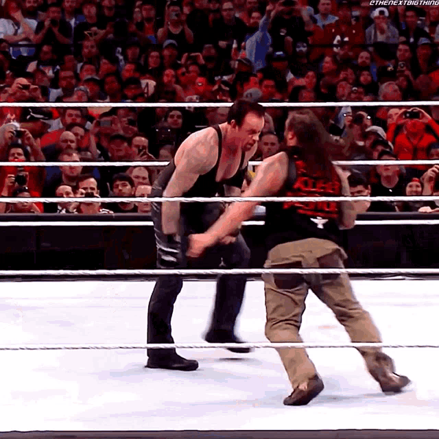two men in a wrestling ring with one wearing a shirt that says killer
