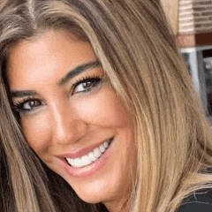 a close up of a woman 's face smiling with long blonde hair .