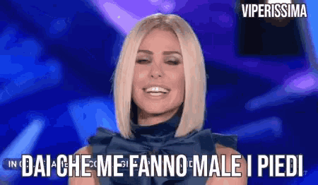 a woman in a blue dress says dai che me fanno male i piedi