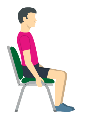 a man in a pink shirt is sitting in a chair with his leg up