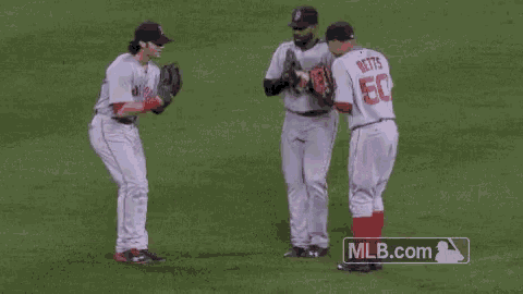 a couple of baseball players standing on top of a field .