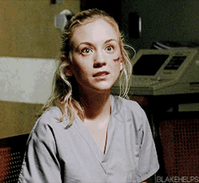 a woman wearing a scrub top with blakehelps written on it