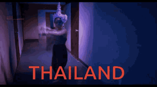 a woman is dancing in a hallway with the word thailand written in red