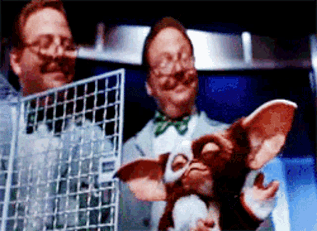 a man holding a gizmo while another man holds a fence