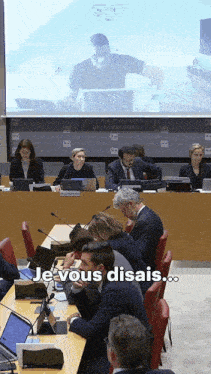 a group of people sitting in front of a large screen with the words je vous disais on it