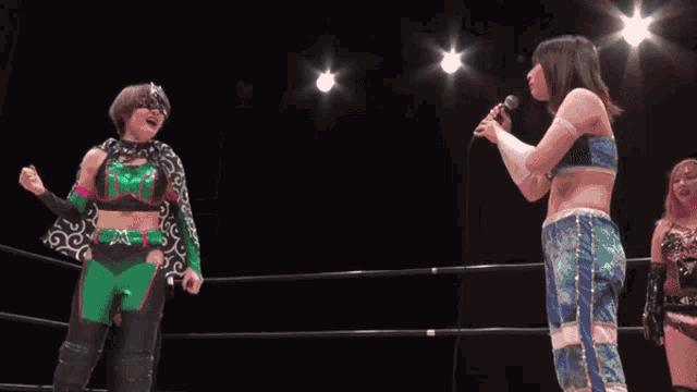 a wrestler is laying on the floor in a wrestling ring with a referee standing behind him .