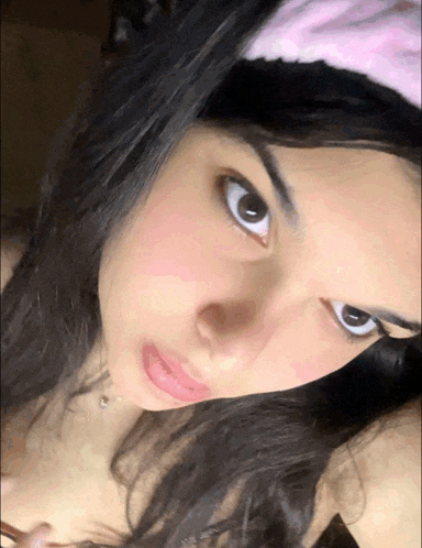 a girl with a pink headband on her head looks at the camera