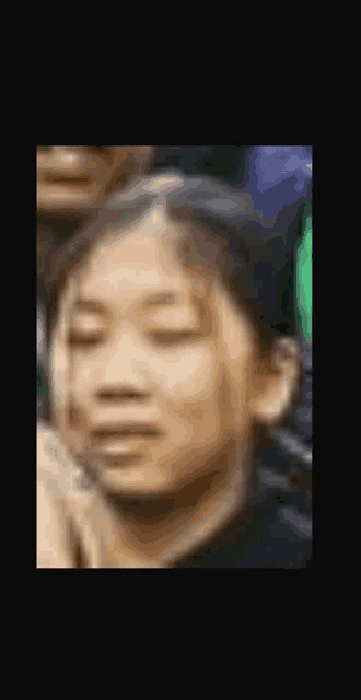 a blurry picture of a girl 's face with her eyes closed