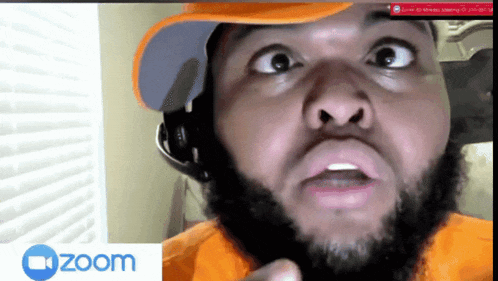 a man with a beard wearing a hat and headphones is on a zoom video call