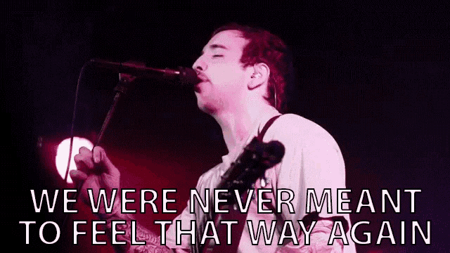 a man singing into a microphone with the words " we were never meant to feel that way again "