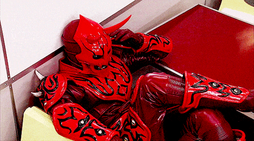 a man in a red costume with horns is sitting on a couch