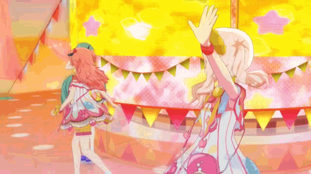 a group of anime girls are standing in front of a stage .