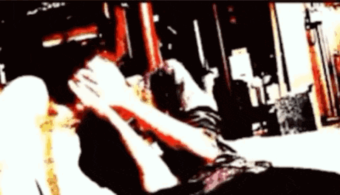 a blurry picture of a person laying on a bed holding a cat .