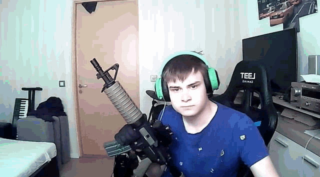 a man wearing headphones and holding a gun in a room