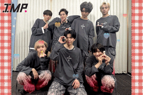a group of young men are posing for a picture and one of their shirts says tmp