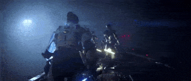 a group of people are standing next to each other in the dark .
