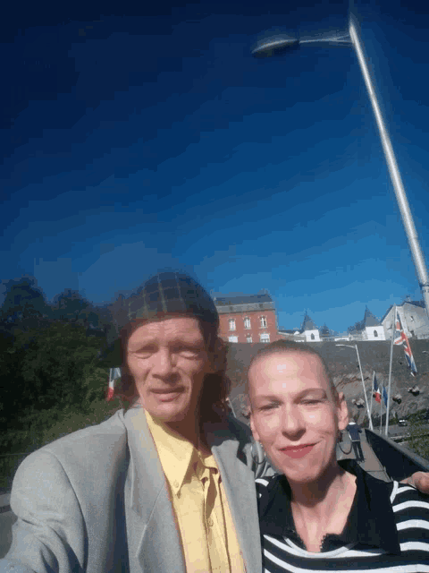 a man in a suit and a woman in a striped shirt pose for a photo