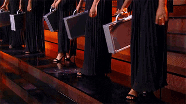 a row of women holding briefcases with numbers on them
