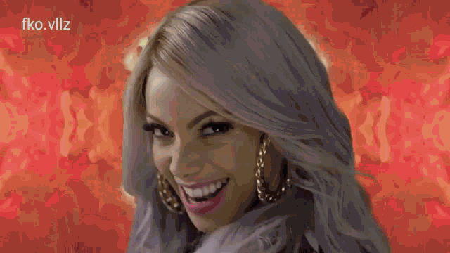 a woman with gray hair and gold hoop earrings smiles in front of a yellow and green background ..